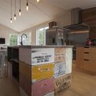 Bee boxes and whisky cases are built into the kitchen bench in this Arrowtown holiday home....