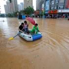 Residents make their way with an inflatable boat through a flooded area in Jiujiang, Jiangxi...