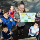 Outram School pupil Brooke McAlwee with a copy of a page from a book of support sent to former...