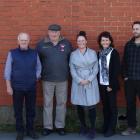 Standing in front of the wall on which a mural will be painted are (from left) mural advocate...