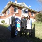 Harcourts Real Estate agents (from left) Mark, Penny and Emma Laughton stand in front of a house ...