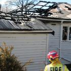 Firefighters mop up after the blaze that engulfed a Wolsley St house in early yesterday morning....