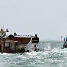 Port Otago' work boat Kapu tows the $1.4million, spoil-laden barge Hapuka out to sea yesterday....