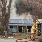 Firefighters work to contain a fire at a Criterion St home in Arrowtown yesterday, which appeared...