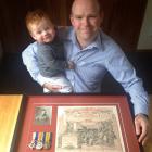 Shawn McAvinue (38) with 7-month-old son Cormac and the service certificate and medals of his...