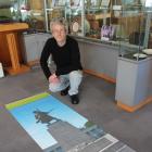 South Otago Museum curator Gary Ross with one of the posters which feature in a display he helped...