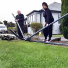 Bill and Pauline Overton inspect the damage to their fence caused when a car ploughed through it....