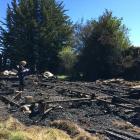 A firefighter examines the remains of the old church destroyed by a fire in Riverton. Photo: Ruby...