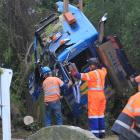 Crews work to remove the cab of the milk tanker after the crash. Photo: Hamish MacLean.