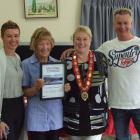 June Stewart holds her mayoral citation, accompanied (from left) by her son's partner Dawn...