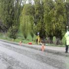 Constable Jack McGilbert (right), of the police serious crash unit, marks points in Ballantyne Rd...