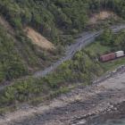 A freight train sits where it came to a halt beside State Highway 1, on the coast north of...