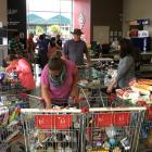 With aisles roped off, shoppers rummage for supplies from the jumble of shopping trolleys at...