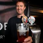 Luc Waite  from Sidewinder brewery in Wanaka serves up a pint of pale ale at the Wanaka Beer...