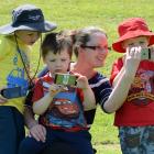 Playing an augmented reality smartphone game at Caversham Reserve yesterday are Eloise Sime and...