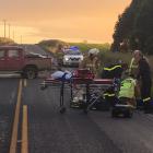 Emergency services staff help a man injured in a crash near Clinton yesterday morning. Photo:...