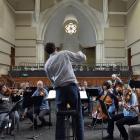 David Burchell conducts the Dunedin Symphony Orchestra, surrounded by acoustic panels, for its...