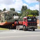 A gold dredge is towed through Roxburgh as it is moved from the town to Beaumont yesterday. Photo...