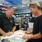 Paper Plus Wanaka manager Chris Lumsden takes an order from Penny Riley in Wanaka yesterday for a...