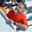 Irish sailor Enda O’Coineen watches as a replacement mast is mounted on his racing yacht,...