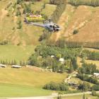 A helicopter crew searches for the missing parapenter below Coronet Peak skifield yesterday....
