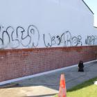 Volunteers clean graffiti from a wall at St Gerard’s School in Alexandra on Thursday  after a...
