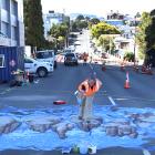 Artist Jenny McCracken works on the new 3-D pedestrian crossing with Downer contractor Nathan...
