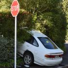 A white sedan rests on a Dunedin footpath yesterday after hitting a wall and fence. Photo: Gregor...