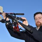 Otago Fish &amp; Game officer Morgan Trotter yesterday holds fishing rods confiscated from...