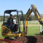 Oamaru's Chris Manson guides Richard Collins (3) through the delicate operation of a digger....