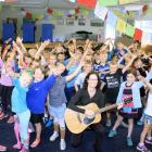 Cathy Irons (centre) leads a group of Hawea Flat School year 3 and 4 pupils through a song...
