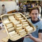 King's High School pupil Duncan Trevithick holds up a tray of some of the 36,000 cheese rolls prepared for fundraising for a sports trip by the school to South Africa next year. Photo: Gerard O'Brien.