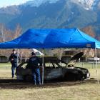 Police examine the burned-out car in Queenstown's Jardine Park yesterday. PHOTO: GUY WILLIAMS