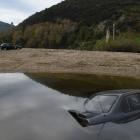 A Nissan Primera was driven into the Taieri River and a Sentra was abandoned on the riverbank at...