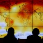Participants look at a screen showing a world map with climate anomalies during a World Climate...