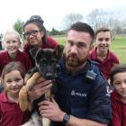 Constable Regan Mauheni, of Dunedin, and general purpose police dog-in-training Vann meet Clutha Valley Primary School pupils (clockwise from front left) Tallulah Flame (7), Bridee Lumb (11), Mari Chacapna (12), Elliot Hunter (9) and Alfie Flame (9). Phot