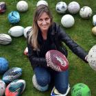 Otago Polytechnic student Carla Hore displays part of a donated collection of used sports balls....