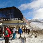 Skiers and snowboarders queue at the base of the new McDougall’s Chondola ski lift on opening day...