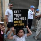 A girl holds a placard during a demonstration in favour of a peace settlement between Greek and...