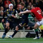 Gareth Evans slips through the tackle of Robbie Henshaw of the Lions during the Highlanders vs...