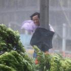 A man holds on to a lamp post as Typhoon Hato hits Hong Kong. Photo Reuters 
