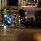 Forensic police officers search for clues near the area where a van crashed into pedestrians at...