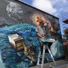 Guy Howard-Smith works on his street art mural in Castle street earlier this year. Photo: ODT.