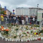 People mourn next to memorial candles and flowers at the Market Square in Turku. Photo: Reuters