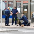 The suspect lies on the ground surrounded by police officers at the Market Square where several...