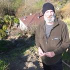 Oamaru man Gordon Stringer stands on what used to be a bank before it slipped and part of it...