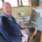 Alexandra artist Denis Kent works on a painting in his home studio. Kent, whose artworks have...