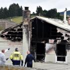 Police and emergency services staff attend the scene of a house fire in Brockville on Saturday...