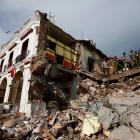 Soldiers remove the debris of a house destroyed in an earthquake that struck off the southern...