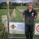 Yellow-eyed Penguin Trust ranger Ben Goldsworthy installs the first sign at Tavora Reserve, near...